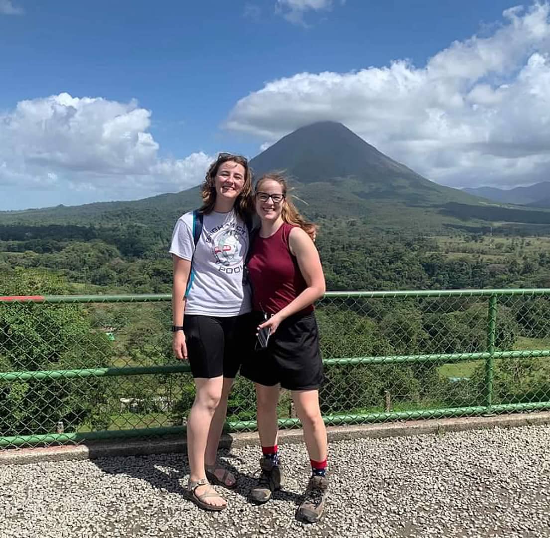 Two tourists in front of the Arenal Volcano