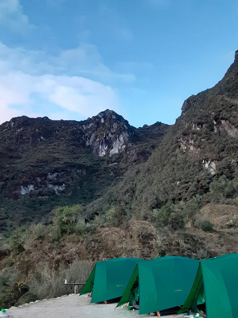 row of green tents against the backdrop of the andes mountains