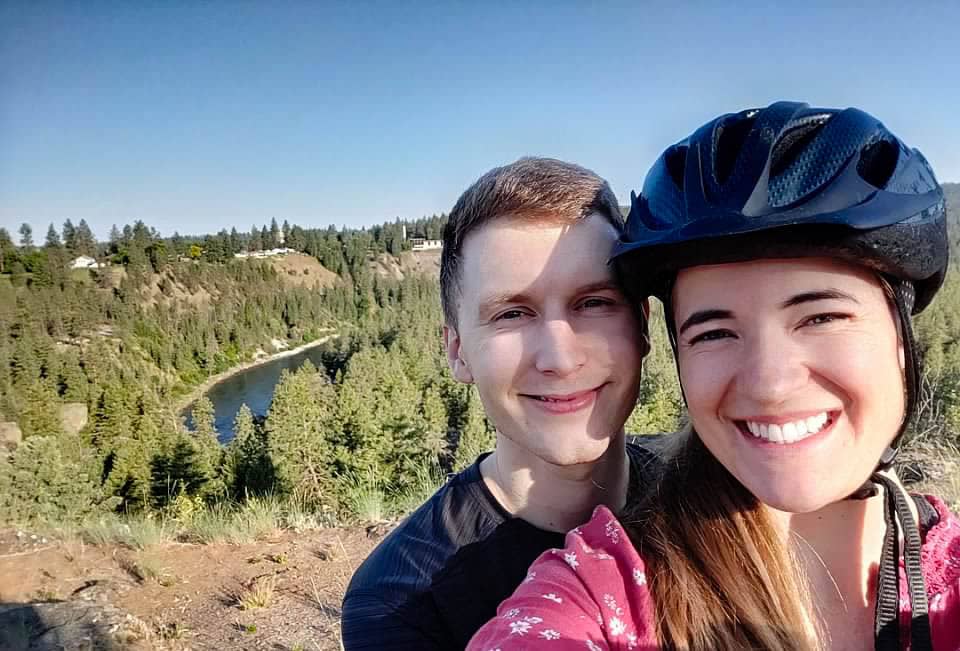 two people posing above the Spokane river having biked along the Centennial Trail